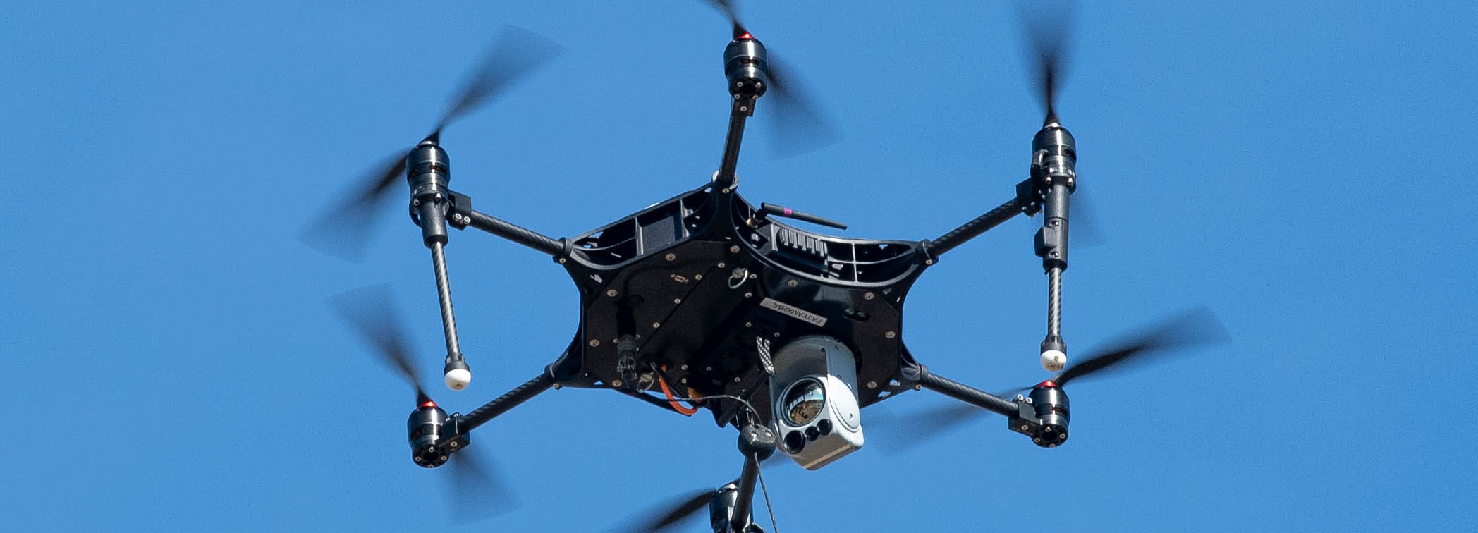A photo of a drone hovering in the air.