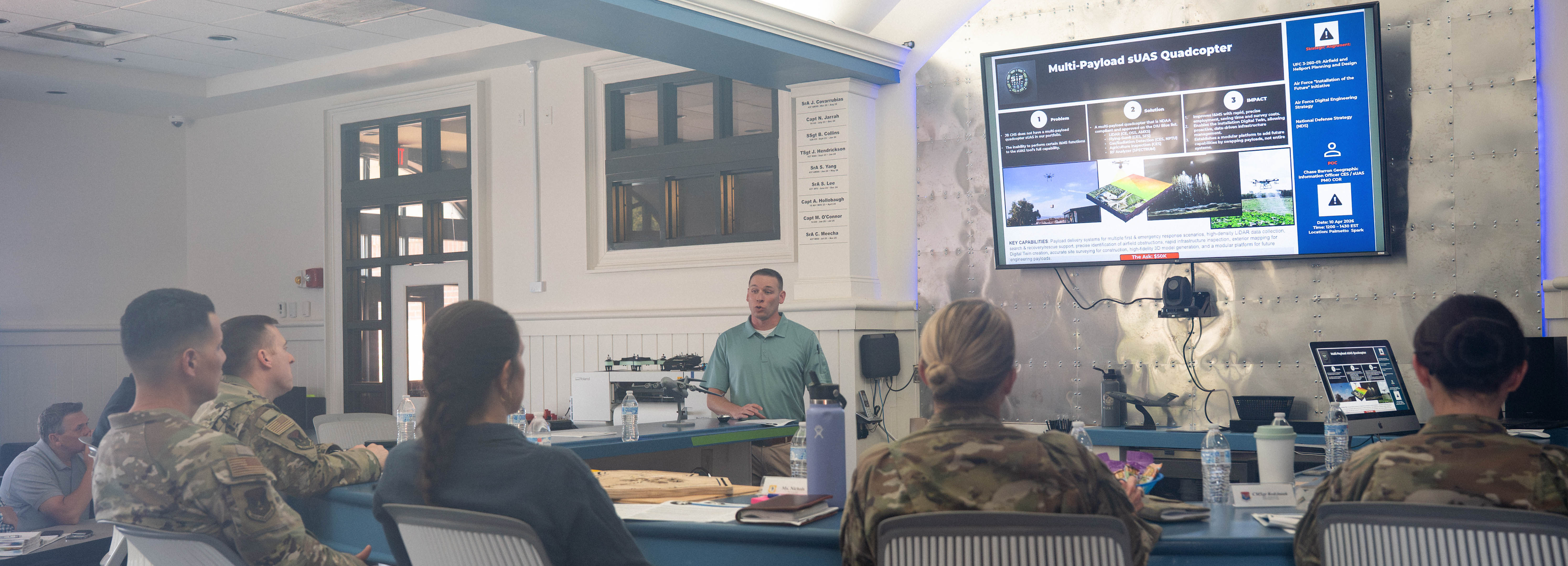 A photo of a man giving a presentation to base leadership.