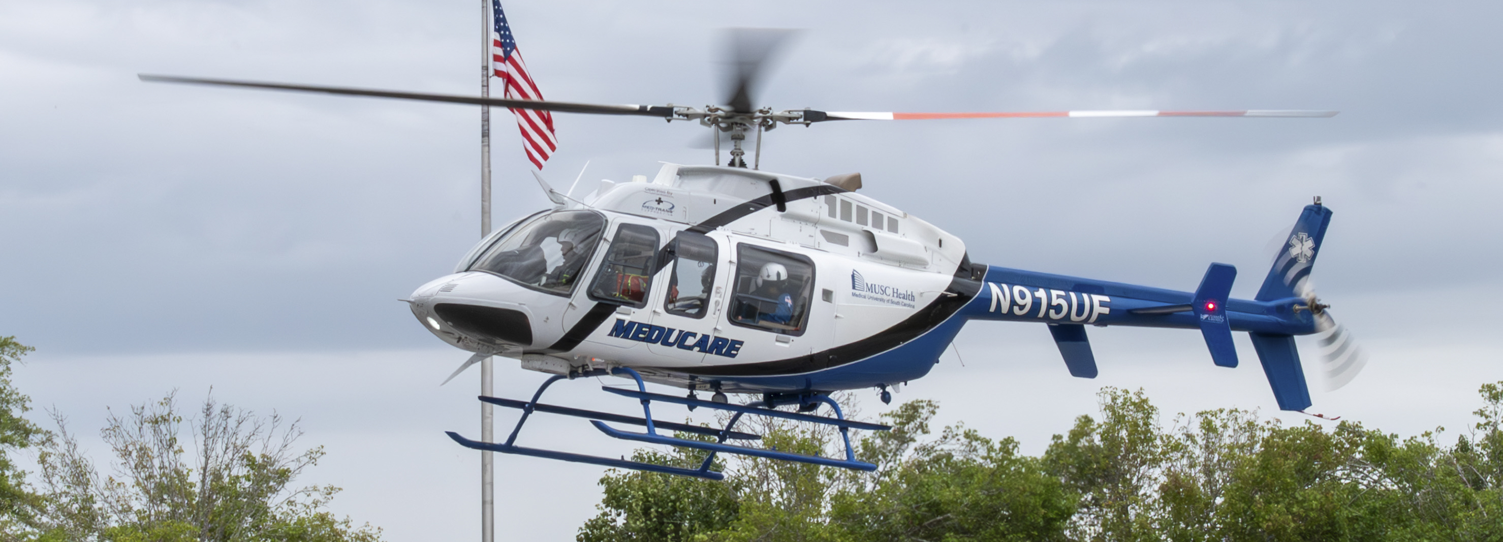 A helicopter prepares to land in a parking lot during a medical exercise.