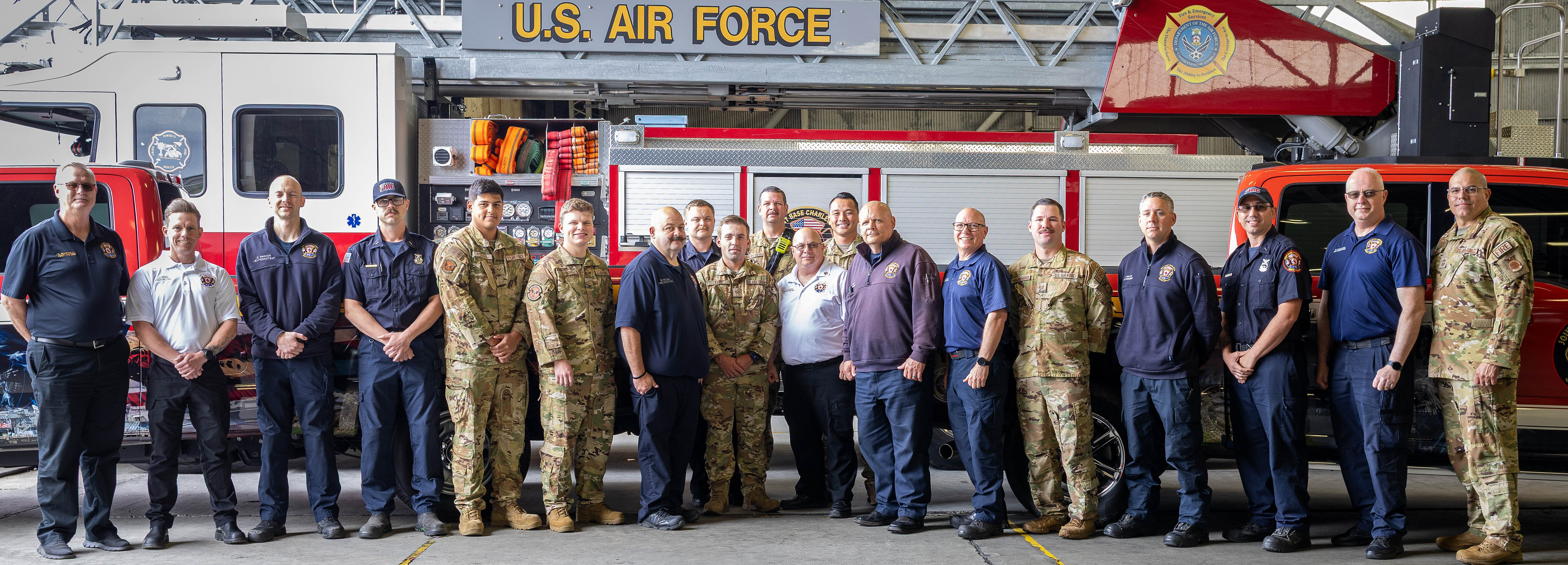 A photo of the 628th Civil Engineer Squadron Fire Prevention team standing together for a photo. The team is in a large garage with a fire truck in the background.