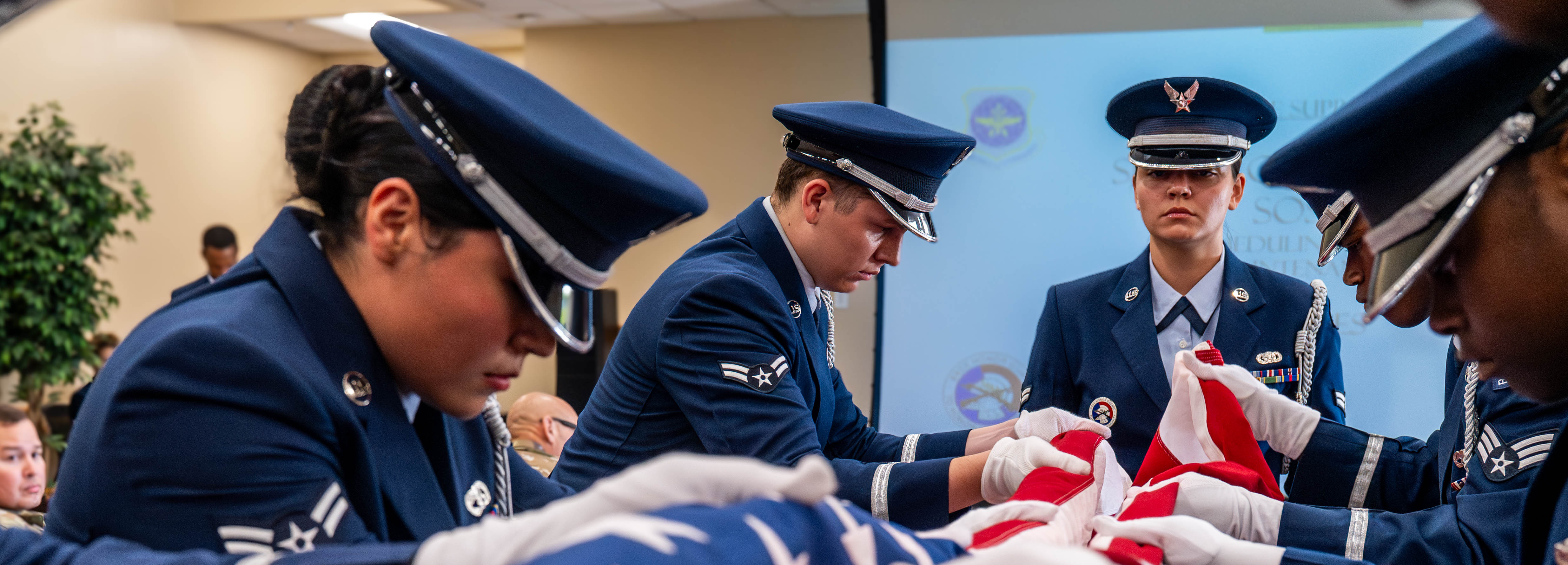A photo of honor guard members demonstrating a Pallbearer Ritual inside of a building.