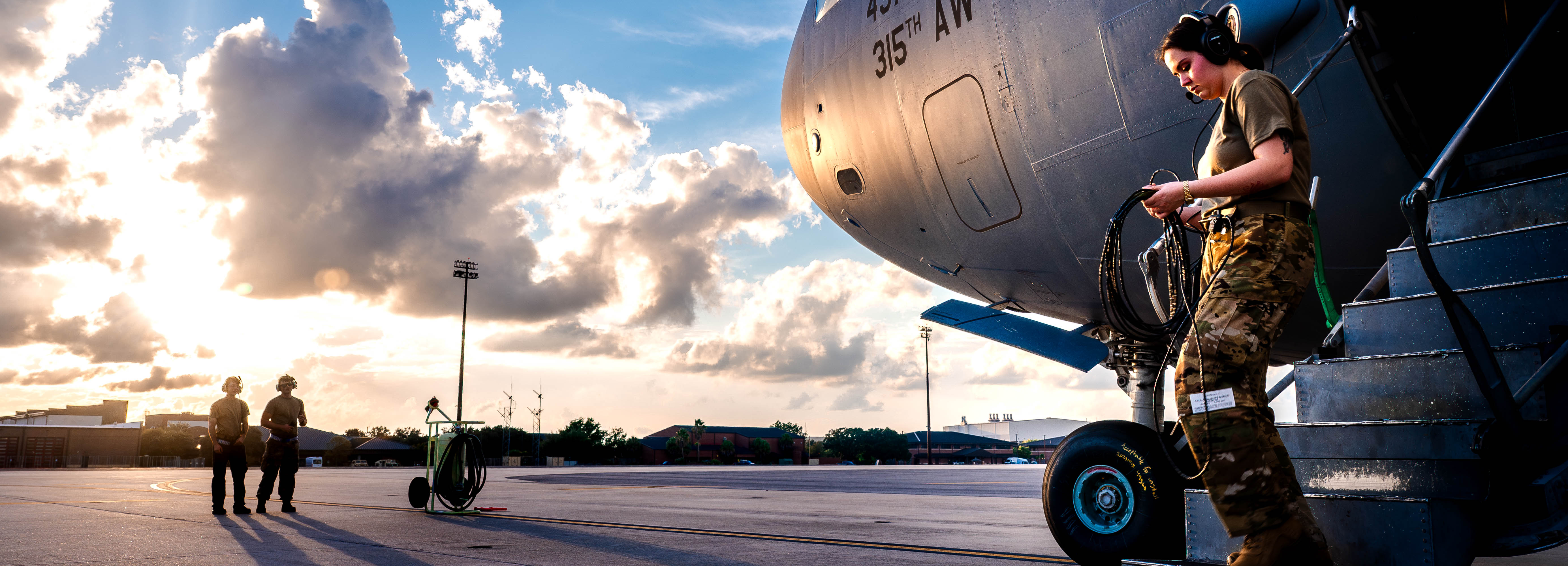 A photo of a U.S. Air Force Airman walking down the ramp of a C-17 Globemaster III with two more Airmen in the background.