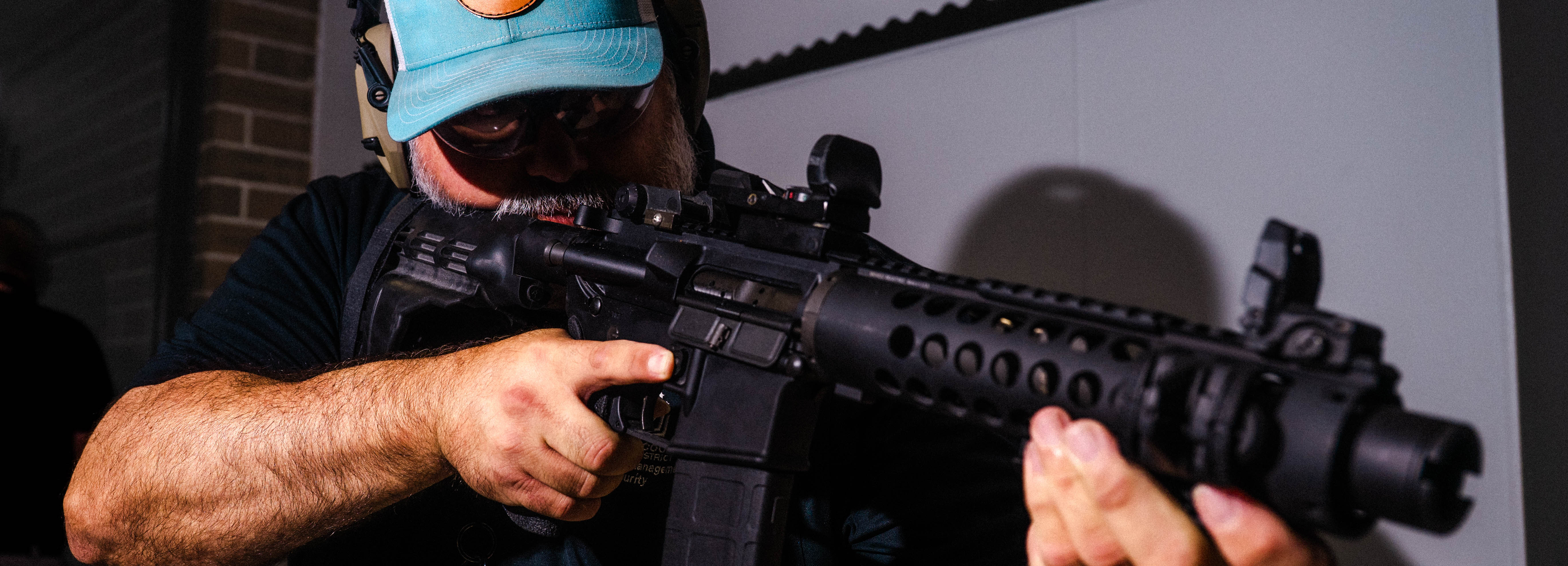 A photo of a man in a hallway holding an M4 rifle.