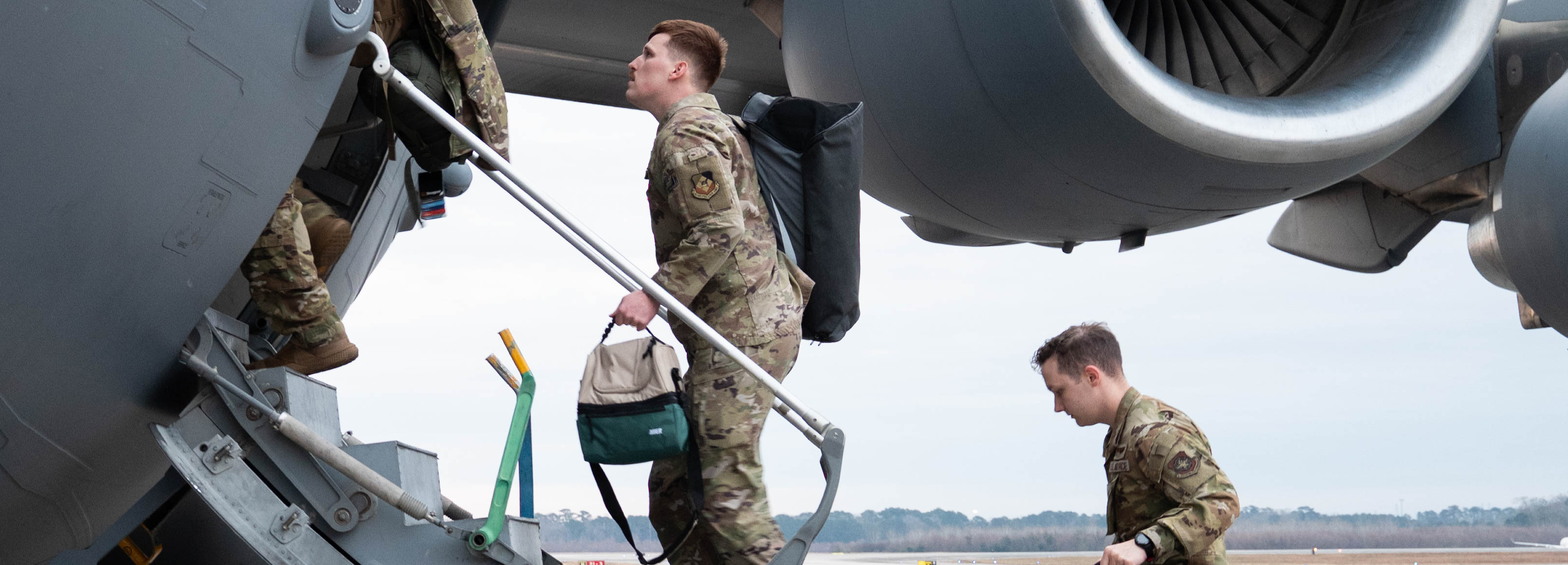 Airmen step up stairs leading into a C-17.